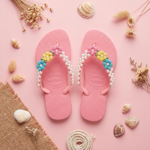 Havaianas rosa com pérolas sobre renda de noiva