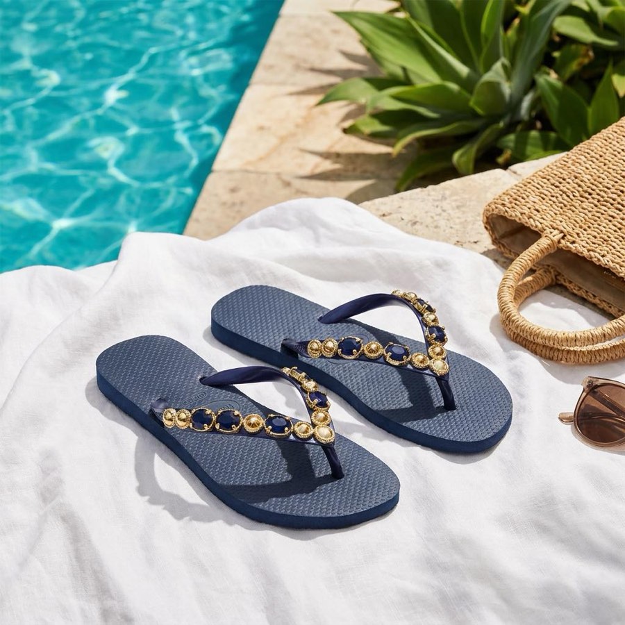 Chinelo Havaianas azul-marinho com pedrarias douradas, à beira da piscina